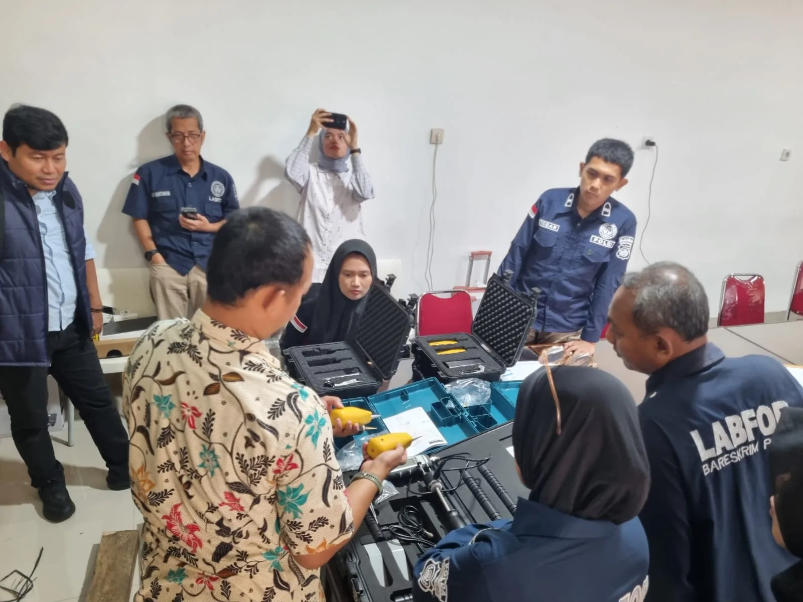 Peserta pelatihan mengamati peralatan pemeriksaan kayu di ruang praktik Puslabfor